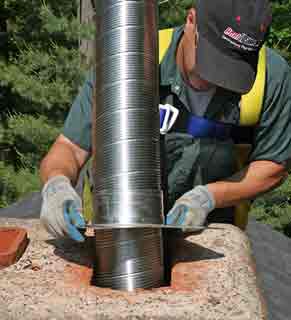 Chimney Liner - Photo of a man installing a stainless steel liner in a chimney.