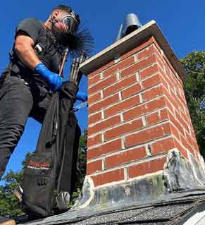 Chimney Cleaning - Photo of a man getting ready to clean the creosote buildup in the chimney.